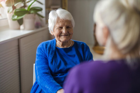 Elderly woman talking to her caregiver in the nursing homeの写真素材