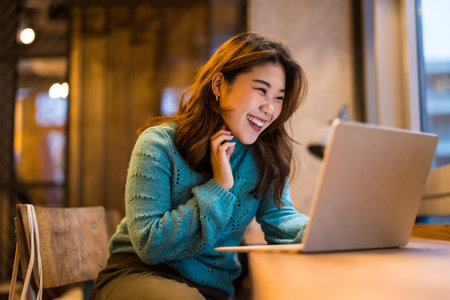 Portrait of beautiful asian woman using laptop computer in coffee shopの写真素材