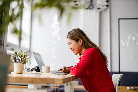 Portrait of a smiling businesswoman sitting at a tableの写真素材