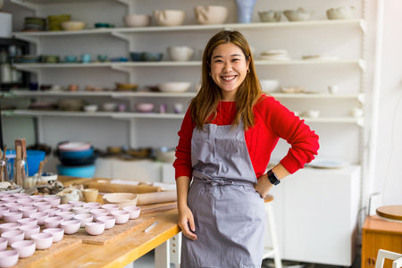 Portrait of smiling female potter standing in her pottery workshopの写真素材