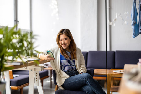 portrait of smiling asian woman using mobile phoneの写真素材