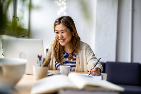 Portrait of a beautiful young asian woman working at home officeの写真素材