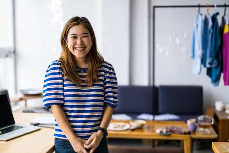 Portrait of smiling businesswoman standing in creative officeの写真素材