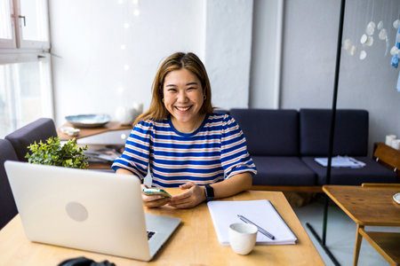 Smiling asian businesswoman using credit card and laptopの写真素材