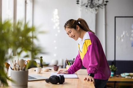 Portrait of a young woman working at her desk in an officeの写真素材
