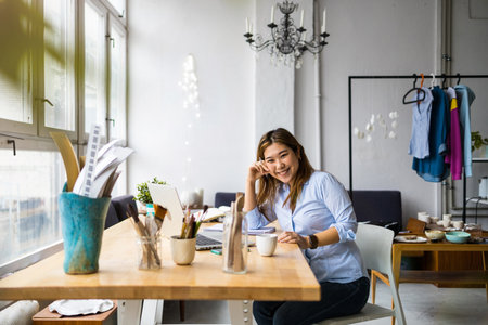 Portrait of a young businesswoman sitting at table in officeの写真素材