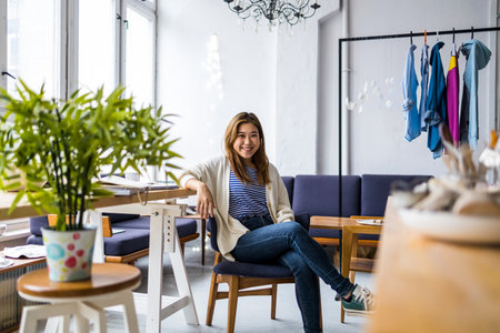 Portrait of a smiling businesswoman sitting on a chairの写真素材