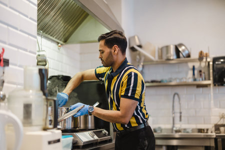 Portrait of a man preparing food in the kitchen at the restaurantの写真素材