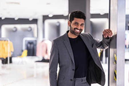 Portrait of a happy young businessman standing at the entrance to a clothing storeの写真素材