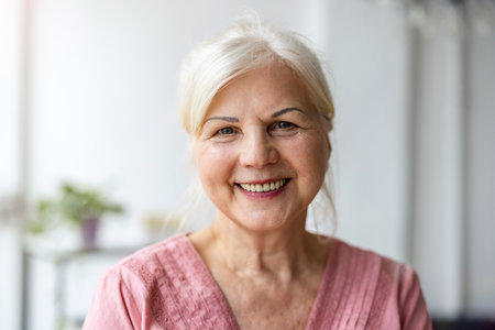 Portrait of smiling senior woman looking at camera at home. Mature female looking at camera and smiling.の写真素材