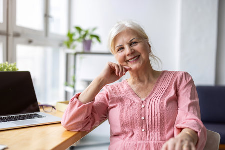happy senior woman with laptop computer at home office. Mature businesswomanの写真素材