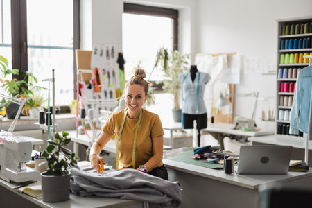 beautiful young fashion designer working on her designs in a modern studioの写真素材