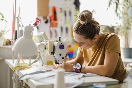 Fashion designer woman working on her designs in a studio. Female fashion designer working on her designs.の写真素材
