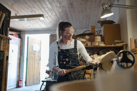 Portrait of mature female carpenter working in her woodwork studioの写真素材