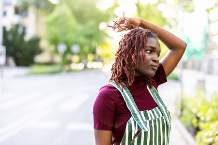 african american woman in apron with dreadlocks looking awayの写真素材