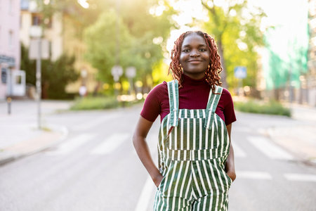 african american woman in striped apron standing on city streetの写真素材