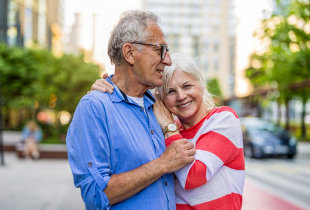 Portrait of happy senior couple embracing each other in a city streetの写真素材