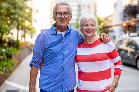 Portrait of happy senior couple standing in city street on a sunny dayの写真素材