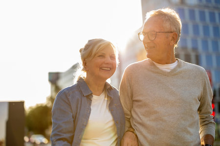 Senior couple walking in the city. They are looking at camera and smilingの写真素材
