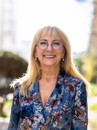 Portrait of a smiling senior woman with eyeglasses in the parkの写真素材