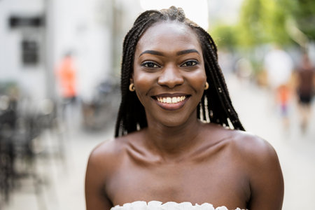 Portrait of a beautiful young woman with braids in the cityの写真素材