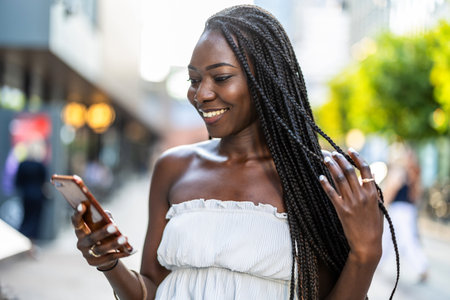 Beautiful african american woman using mobile phone in the cityの写真素材