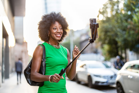 Young african american woman taking selfie with mobile phone on the streetの写真素材