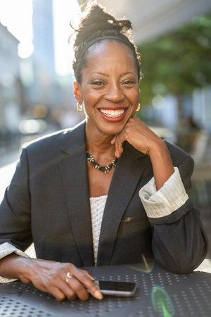 Portrait of smiling mature businesswoman using mobile phone in urban settingの写真素材