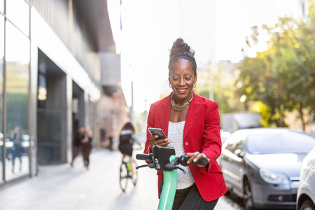 Portrait of young businesswoman using mobile phone while riding electric scooterの写真素材