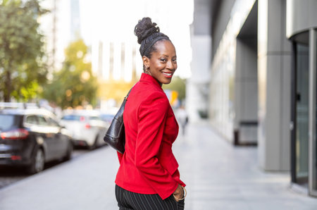 Portrait of a smiling african american businesswoman in red jacketの写真素材