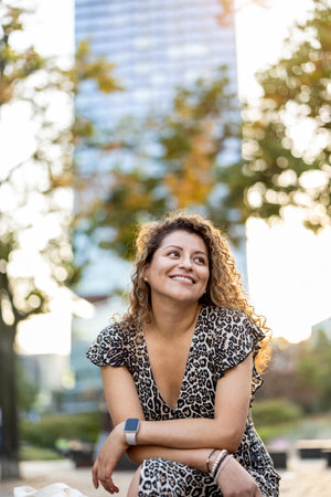 Portrait of a beautiful young woman with curly hair in the cityの写真素材