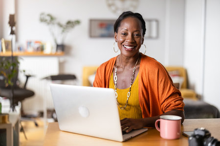 Portrait of smiling african american businesswoman using laptop in officeの写真素材
