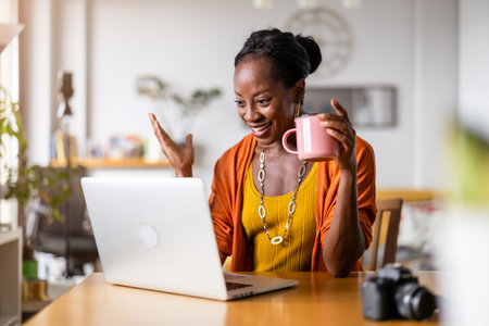 Portrait of smiling african american woman using laptop in officeの写真素材