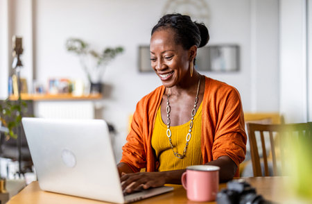 happy african american woman using laptop at home office. social distancing conceptの写真素材