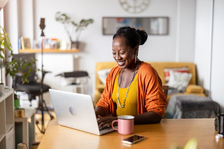 Portrait of smiling african american businesswoman using laptop in officeの写真素材