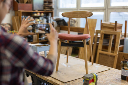 Carpenter working on a wooden chair in a workshop, close-upの写真素材