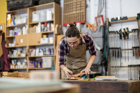Portrait of a female carpenter working on a piece of woodの写真素材