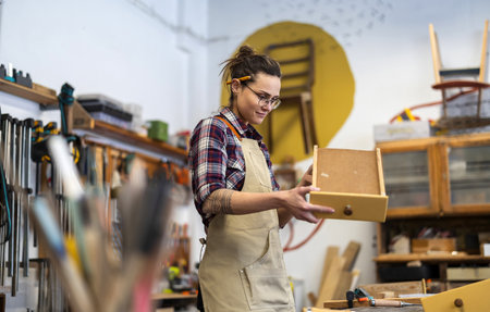 Portrait of a female carpenter standing in her workshopの写真素材