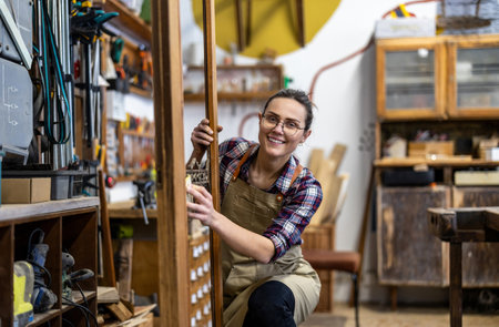 Portrait of a female craftsman smiling at camera in his workshopの写真素材