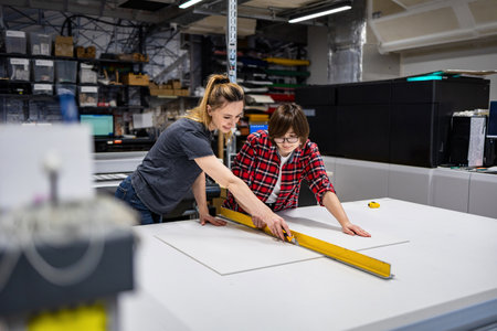 Two Female Engineers Using Measuring Tool In Factory - Shallow Depth Of Fieldの写真素材