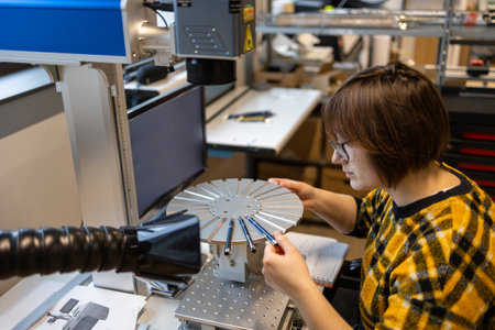 Young woman working on a 3D printer in a modern laboratory.の写真素材