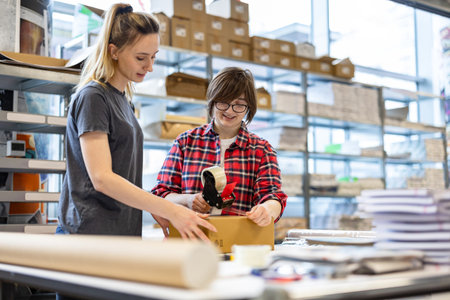 Two young people working together in a furniture store. They are looking at a box and smiling