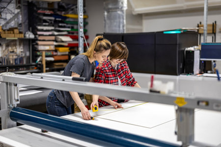 Two female engineers working together on a sheet of paper in a factory