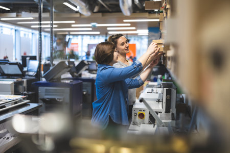 Portrait of young female engineer working on the machine in the factoryの写真素材