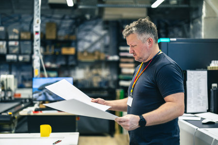 Portrait of a man working in a factory, checking documents.の写真素材