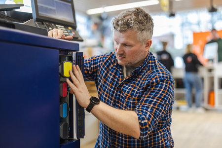 Portrait of a male technician using a machine in a hardware storeの写真素材