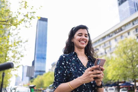 Portrait of a beautiful latin woman using her mobile phone in the cityの写真素材