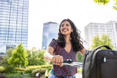 Portrait of happy young woman with her electric scooter in the cityの写真素材