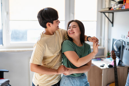 happy asian couple dancing together in modern office at new startup projectの写真素材
