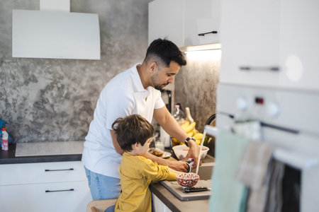 Father and son washing dishes in the kitchen at home. Concept of family time.の写真素材